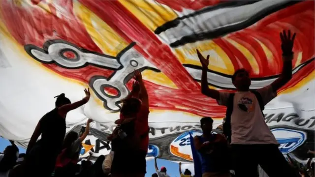 Estudantes2 0 beta hcgmanifestação aparecem embaixo2 0 beta hcgbandeira com tesoura pintada, representando cortes orçamentários