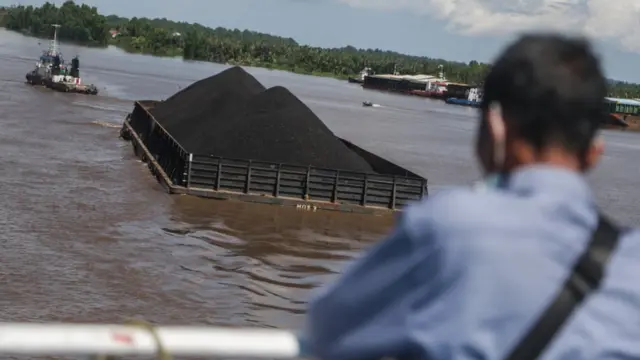 Sebuah kapal tongkang pengangkut batu bara melintas di Sungai Barito, Barito Kuala, Kalimantan Selatan, Senin (20/06)