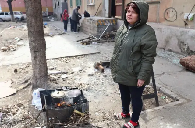 Люди у Маріуполі готують їжу на вогнищі