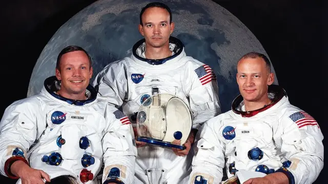 Astronauts Neil Armstrong ඇපලෝ 11 යානයේ ගනම් ගත් නීල් ආම්ස්ට්රෝන් (වම් පසින්), මයිකල් කොලින්ස් සහ එඩ්වින් ඕල්ඩ්රින් (දකුණු පසින්)