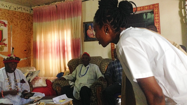 Oge Maduagwu s'inclinant pour saluer un dirigeant traditionnel, lors d'une de ses réunions de plaidoyer