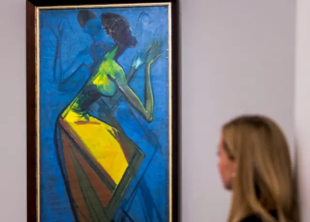 Femme regardant une peinture d'Enwonwu