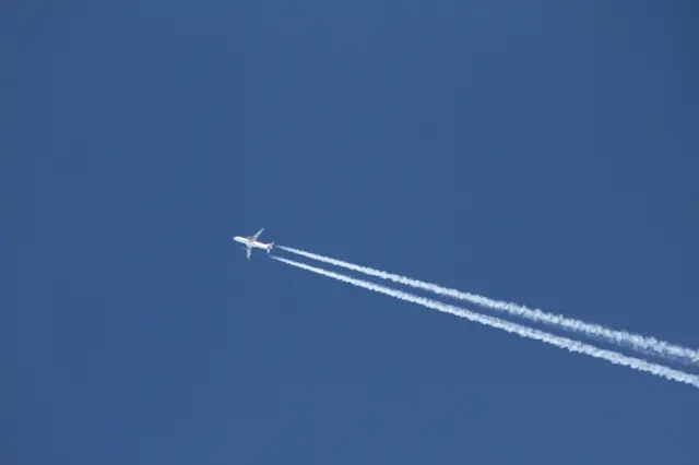 Imagem mostra avião voando, deixando rastroestrategias para apostas esportivasfumaça no céu