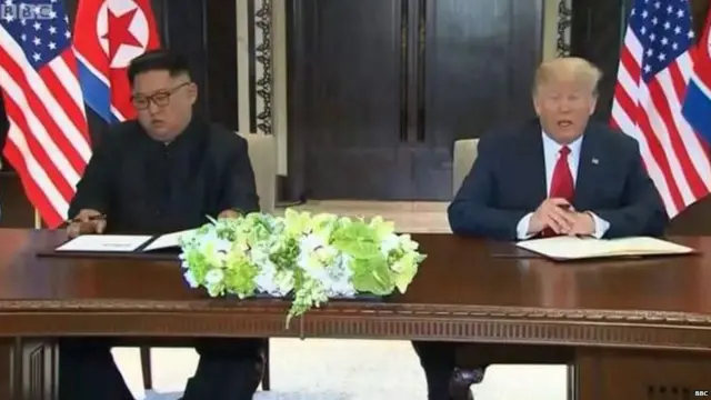 दस्तावेजों पर हस्ताक्षर करते किम जोंग उन और डोनल्ड ट्रंप