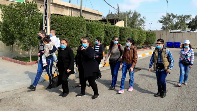 بغداد – أسر مسيحية تسير خارج كنيسة مار كوركيس للكلدان في بغداد للمشاركة في استقبال البابا