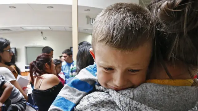 Niño migrante es cargado por su mamá