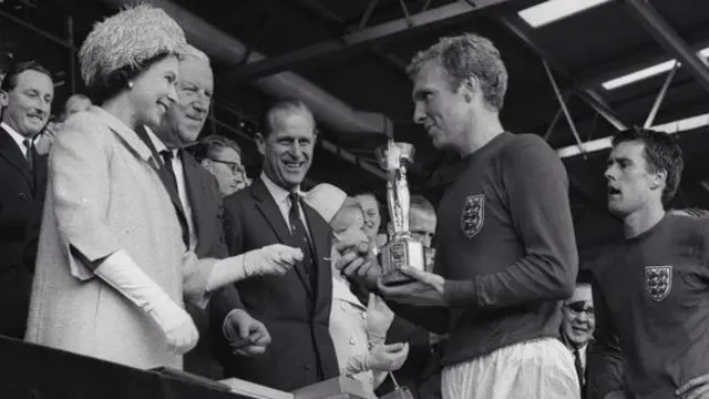 A rainha Elizabeth 2ª entrega a taça da Copa do Mundobet365 muchbetter1966 para Bobby Moore