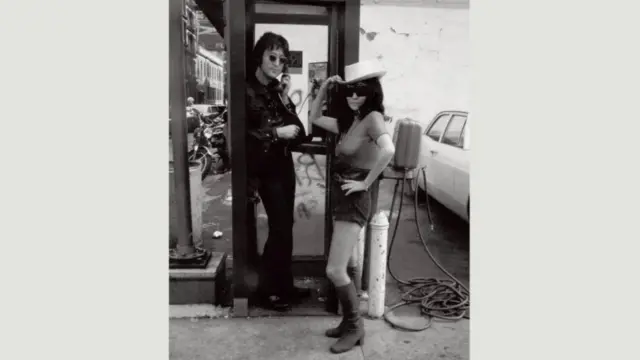 Џон и Јоко у телефонској говорници на тротоару у Њујорку, јун 1971. године