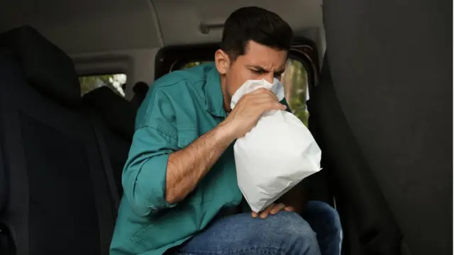 Homem vomitando em carro