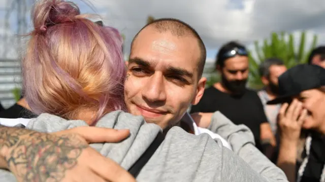 شاب يعانق فتاة مبتسما