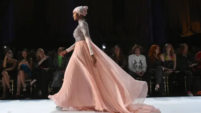 Halima Aden modelling a flowing design by Sherri Hill