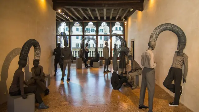 مجسمه های دو نفره که سرشان با یک فنر یا سیم پیچ به هم وصل شده است