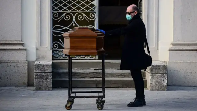 Hombre frente a un féretro en Lombardía