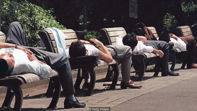 Japoneses dormindoplataforma betanobancos na rua durante o dia