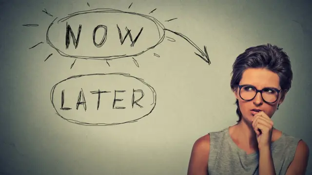 Mujer dudando si hacer una tarea ahora o más tarde.