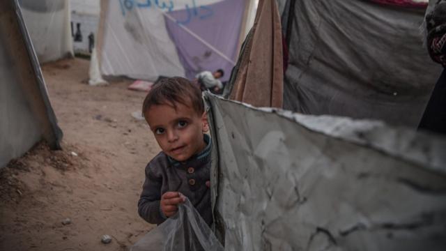 ガザ地区南部ラファでその場しのぎのテントで生活するパレスチナ人の少年（21日）