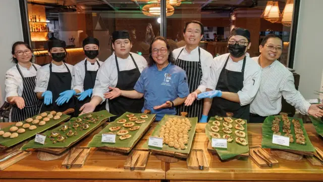 Ekipša kuvara na samitu sa velikim platama na kojima je hrana sa cvrčcima