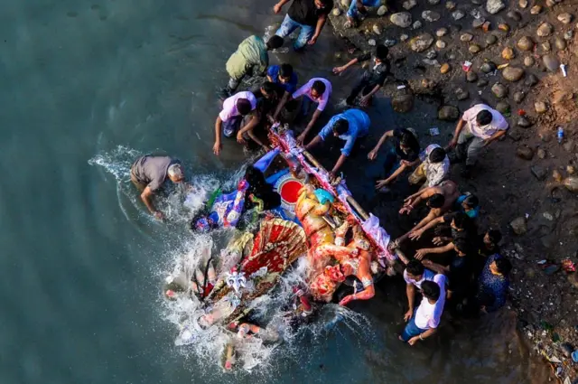 Hindu devotees submerge a clay idol of the Hindu goddess Durga on the final day of the Durga Puja festival in Dhaka on 8 October 2018.