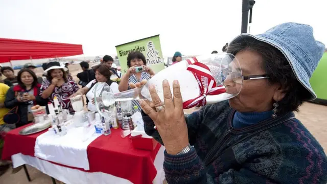 Mujer bebiendo pisco en Perú