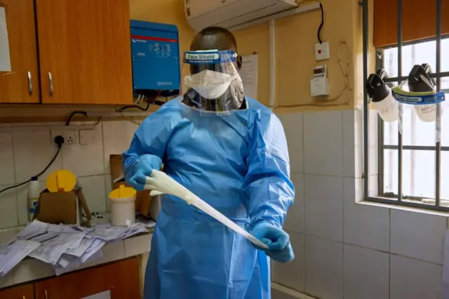 Un technicien de laboratoire enlève ses gants pour tester des échantillons de COVID-19 dans un laboratoire à Juba, au Sud Soudan, le 6 avril 2020.
