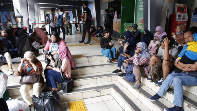 Warga duduk-duduk di Stasiun KRL Sudirman, Jakarta Pusat, yang ditutup karena mati listrik.