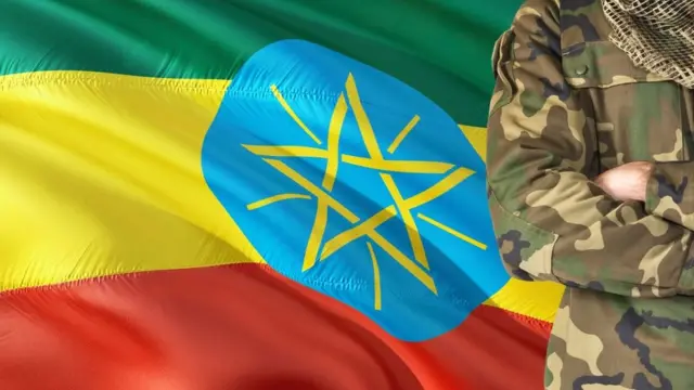 ወታደር ከባንዲራ ፊት ቆሞ