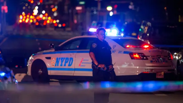 New York City police officers secure and investigate a shooting scene