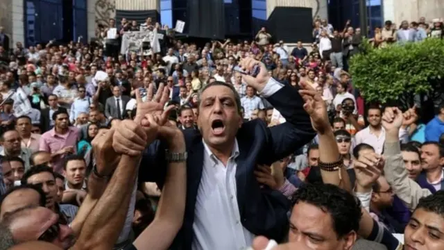 مجموعة من الصحفيين المصريين يحملون نقيبهم، يحيى قلاش، في وقفة احتجاجية أمام مقر النقابة (أرشيف)