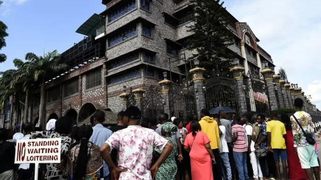 Des habitants et des membres de l'église se rassemblent devant l'entrée principale du siège de l'église synagogue de toutes les nations (SCOA) pour pleurer le décès du pasteur nigérian TB Joshua, dans le district d'Ikotun à Lagos, le 6 juin 2021.