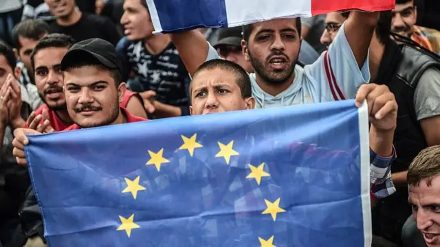 Elinde AB bayrağı taşıyan göçmen