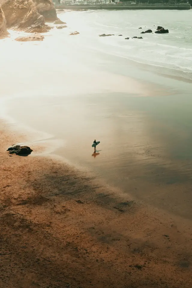 A solitary surfer on an empty Cornish beach