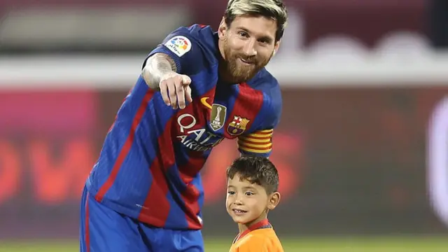 FC Barcelona Lionel Messi talks to Afghan boy Murtaza Ahmadi on the pitch before the start of a friendly football match against Saudi Arabia's Al-Ahli FC on December 13, 2016 in the Qatari capital Doha.