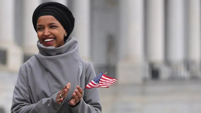 Ilhan Omar segurando bandeirinha dos Estados Unidos