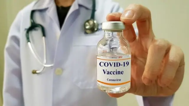 Médico com frasconome de casas de apostasvacina contra covid-19