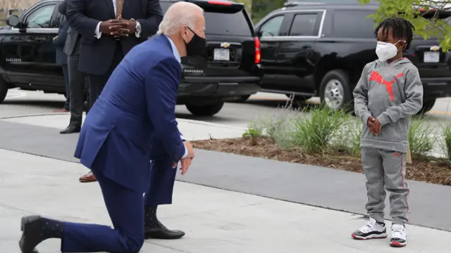 A masked Joe Biden meeting a boy on the campaign trail