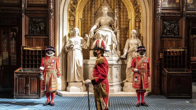 Masked Yeoman warders take up their positions in front of the statue to Queen Victoria outside the House of Lords during the ceremonial search of the Palace of Westminster in London