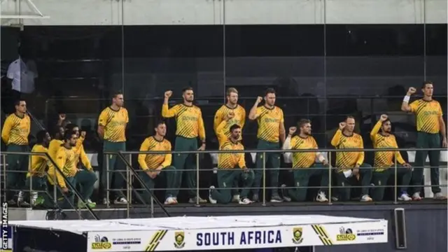 జులైలో దక్షిణాఫ్రికా జట్టు మోకాలిపై నిలబడినప్పుడు ఎడమవైపు విడిగా నిలబడిన డికాక్