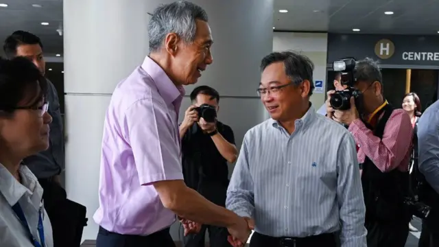 Prime Minister Lee Hsien Loong (2nd L) shake hands with Health Minister Gan Kim Yong during a visit at the National Centre for Infectious Diseases building at Tan Tock Seng Hospital in Singapore on January 31, 2020