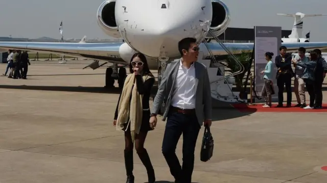 رجل وامرأة من الصين أمام طائرة خاصة