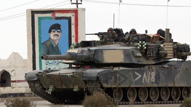 Un char américain dans le sud de l'Irak, quelques jours après le début de l'invasion. Derrière lui, une peinture de Saddam Hussein.