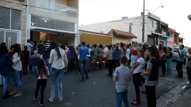 Pessoas na frente da casa onde imagem apareceu