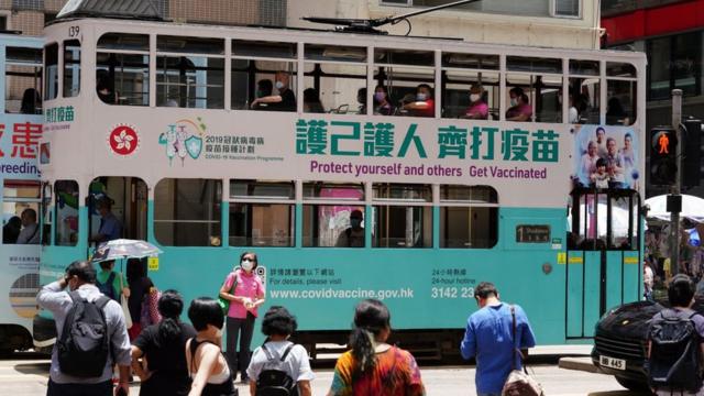 一輛印有「護己護人齊打疫苗」車身廣告的電車駛過香港灣仔街頭（中新社圖片19/5/2021）