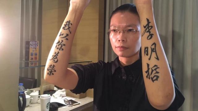 李凈瑜露出双手上"李明哲我以你为荣"的刺青。
