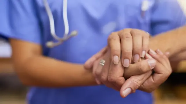 Manos tomadas doctora y paciente