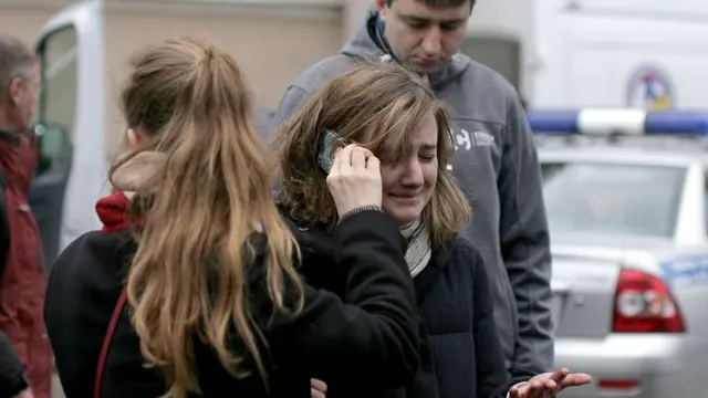 Женщина, плача, разговаривает по телефону около станции метро в Питере