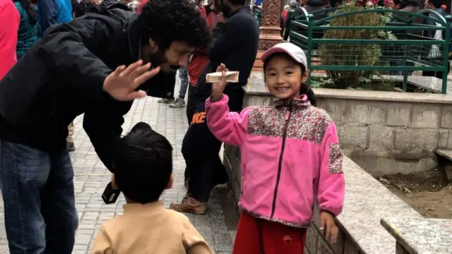 लेह बाज़ार में स्थानीय बच्चों के साथ बीबीसी संवाददाता