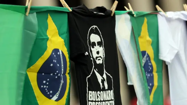 Camisetaentrar pixbet saque rápidoBolsonaro penduradaentrar pixbet saque rápidovaral, ao ladoentrar pixbet saque rápidobandeiras do Brasil