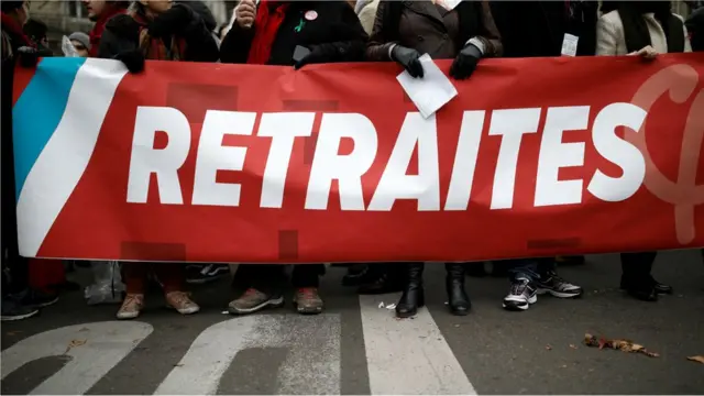 Protesters hold a banner which reads "pensions" during a demonstration against the French government's pension reform plans in Paris as part of a day of national strike and protests in France, 5 December, 2019.