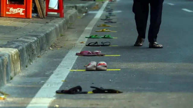 Várias sandálias espalhadas pela rua