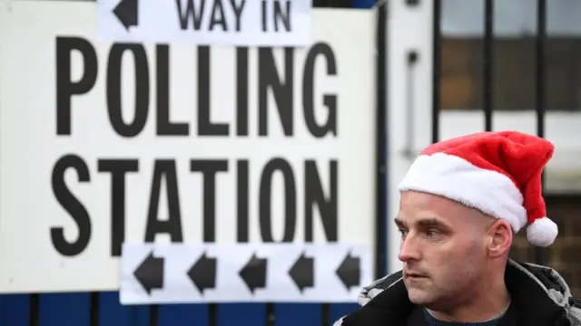 Man for Christmas hat outside one London polling station